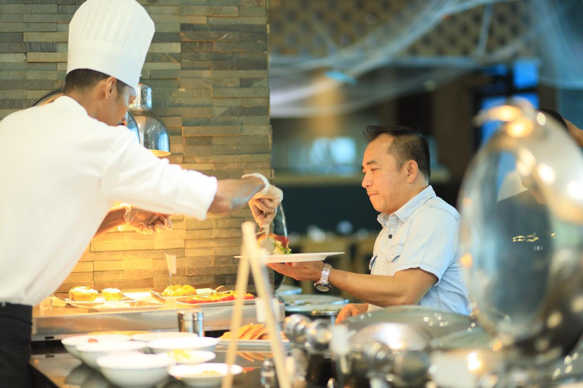 Ramee Grand Hotel And Spa Manama Dış mekan fotoğraf A chef serving food at a buffet